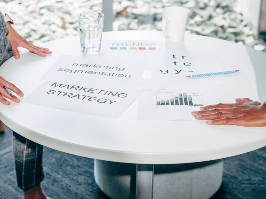 Dois profissionais colaboram na estratégia de marketing e segmentação em uma mesa redonda.